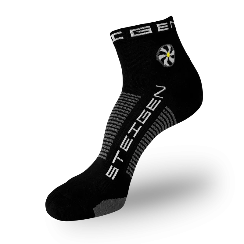 A black Steigen athletic sock featuring a circular white and yellow flower graphic on the ankle. The brand name is printed vertically in white on the foot, with grey and black horizontal stripes wrapping around the arch.