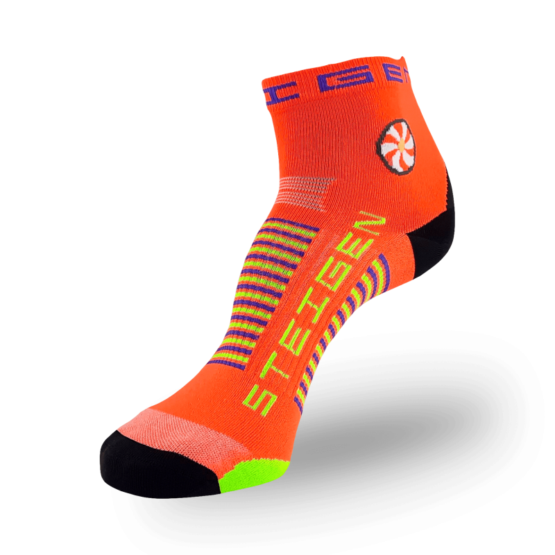 A bright orange athletic sock with a black toe and a neon yellow heel. The ankle features a circular red and white flower-like graphic. The brand name is printed in neon yellow on the foot with purple and neon yellow stripes across the arch.