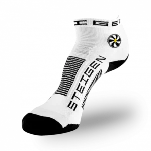 A white low-cut athletic sock with a black toe and heel. It features a circular white and yellow flower-like graphic on the ankle. The brand name "STEIGEN" is printed in black on the foot with black horizontal stripes across the arch.