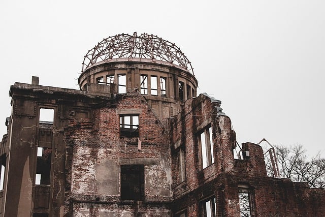 The skeletal remains of a brick building with a large, exposed metal dome structure against a plain, overcast sky.