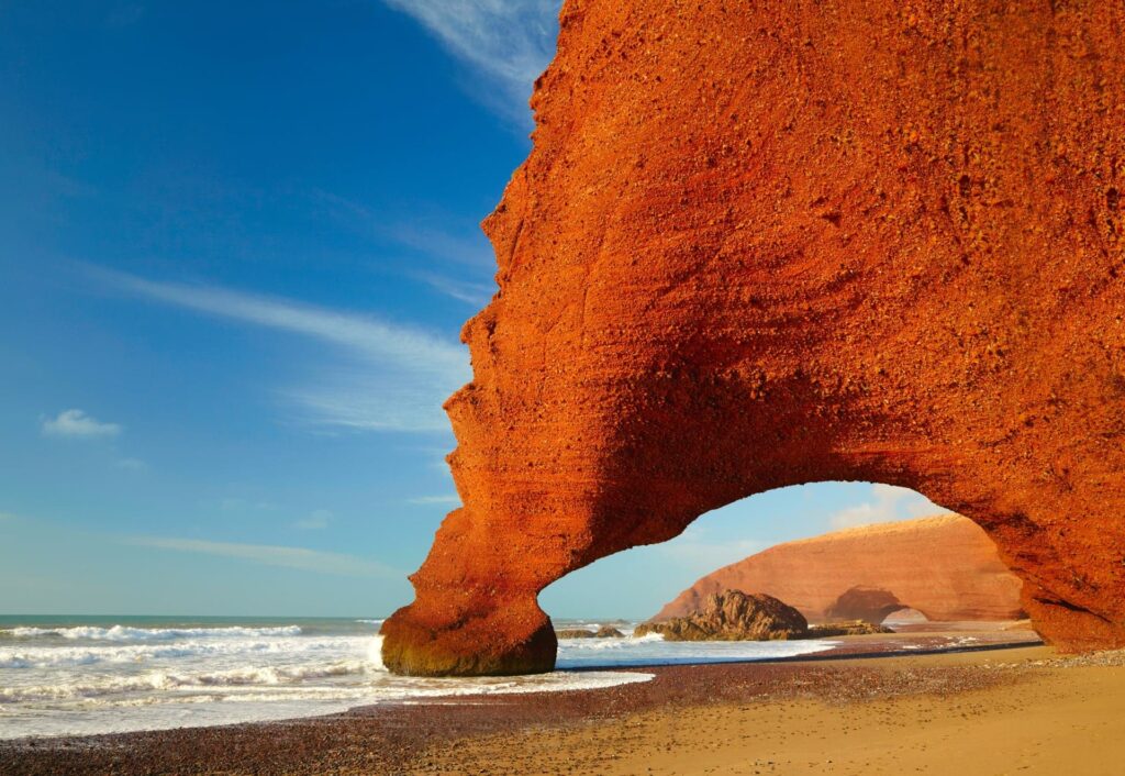 A monumental red sandstone natural arch on Legzira Beach, Morocco.