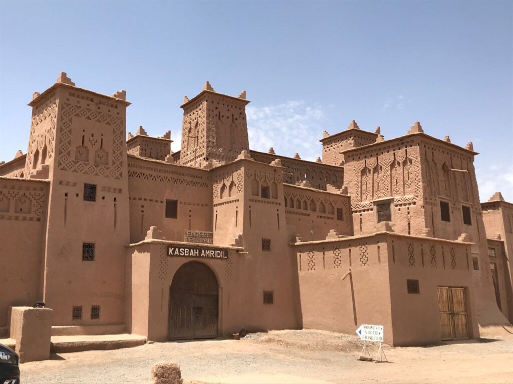 the historic mud-brick Kasbah Amridil in Morocco, featuring traditional architecture and decorative towers.